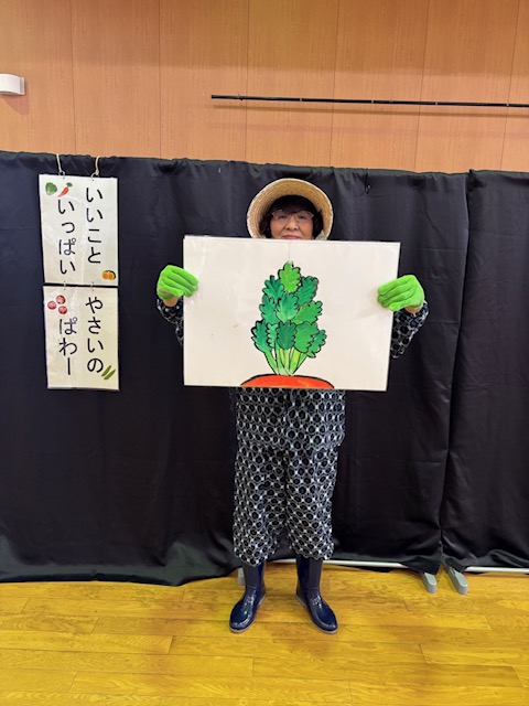 野菜クイズの様子。何の葉っぱかな?ギザギザの葉っぱをもち、細い茎の付け根にはだいだい色が見える。