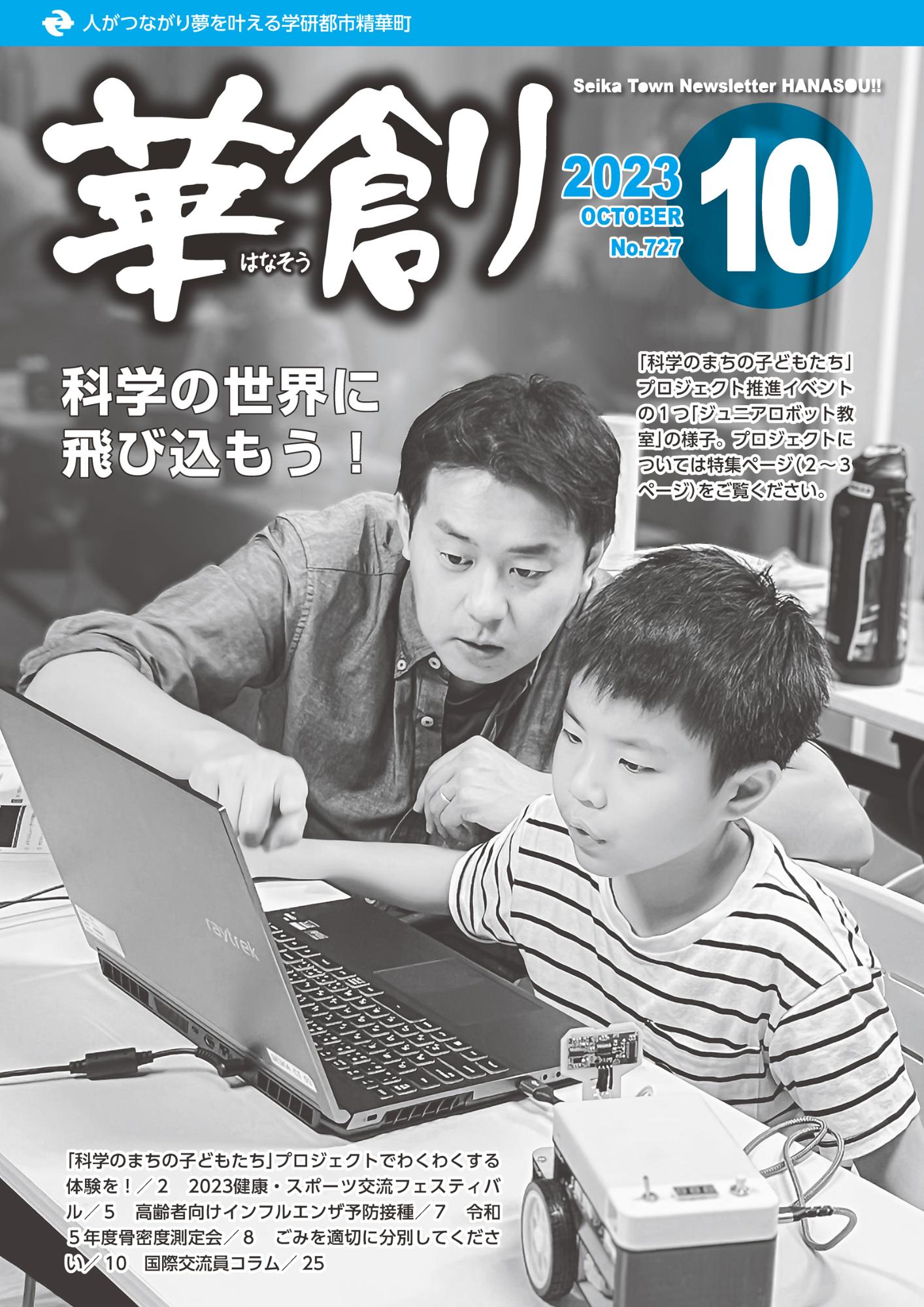 10月号表紙写真：「科学のまちの子どもたち」 プロジェクト推進イベント の1つ「ジュニアロボット教 室」で親子がパソコンの画面を見ている様子。