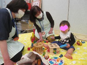 マタニティフェアで主任児童委員さんと子どもが遊ぶ写真