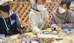 参加者たちが工具に触れながら話し合っているの写真