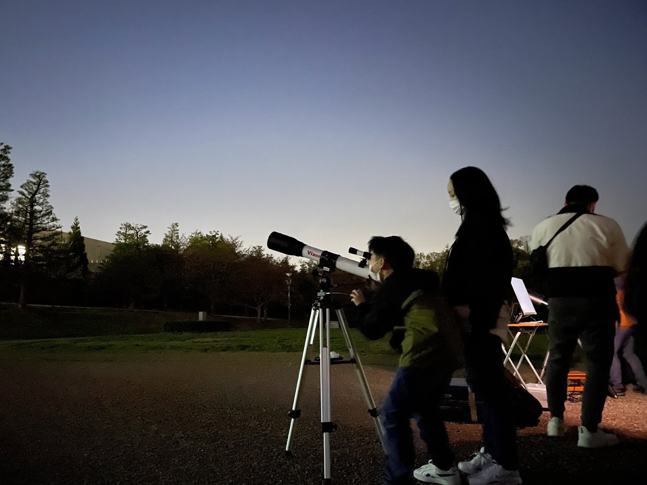 子どもが望遠鏡をのぞいている写真